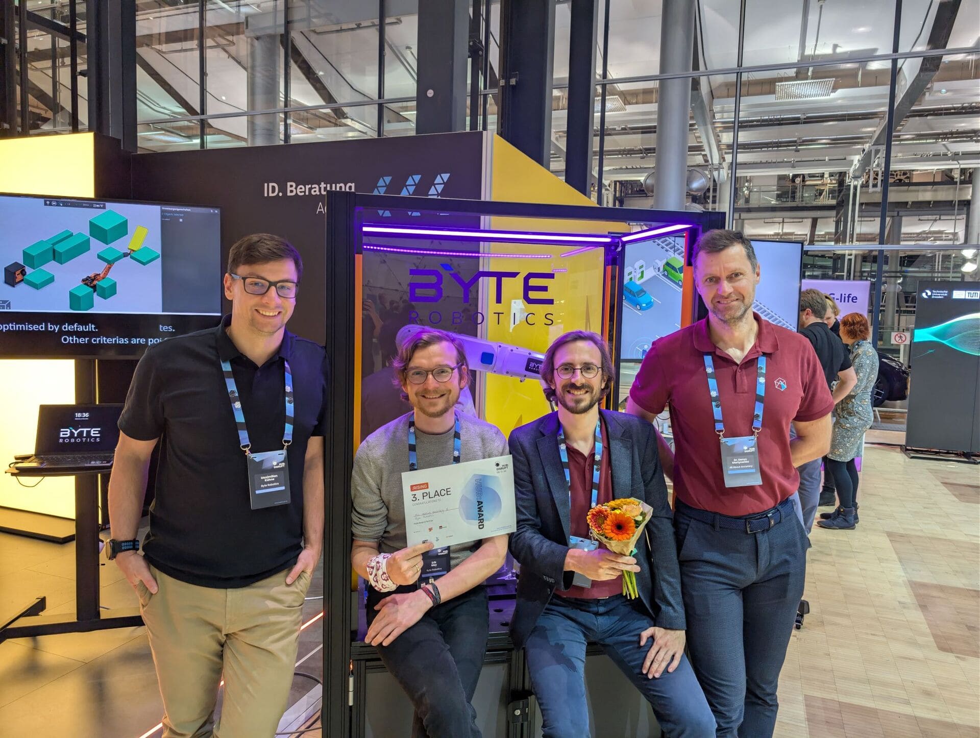 Team von byte robotics mit einer Auszeichnung am Messestand